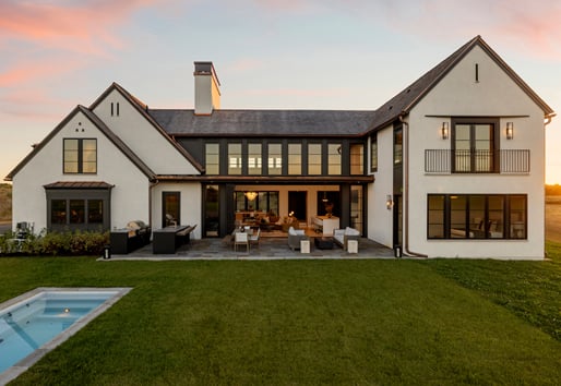 An exterior view of a Modern Tudor with a swimming pool.