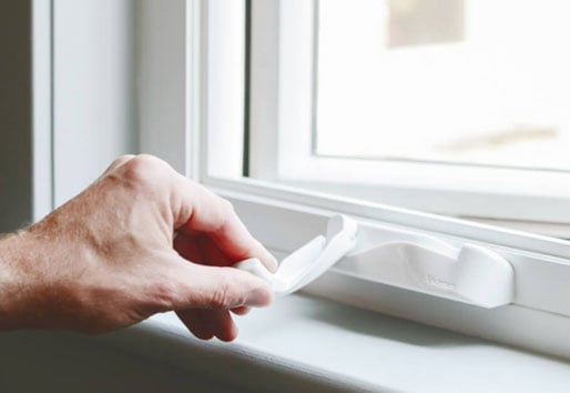 close-up image of hand holding crank on window