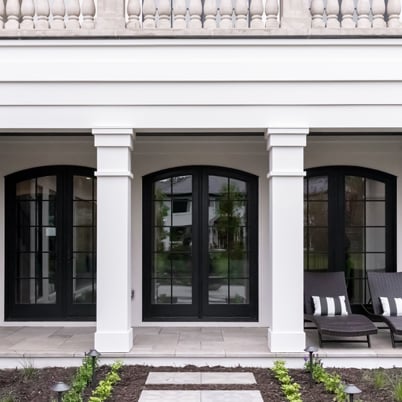 White home with pillars and multiple hinged French doors